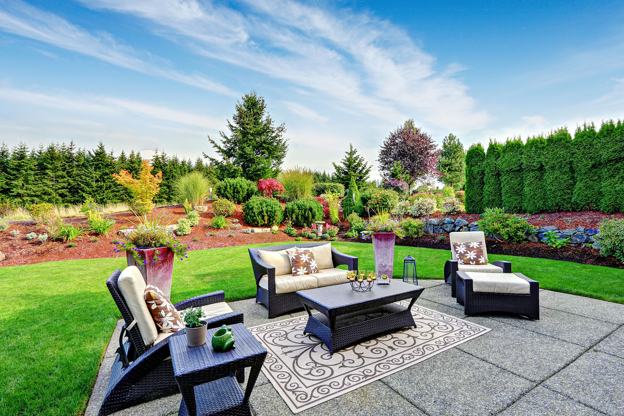 Beautiful patio with outdoor furniture and lush garden landscape