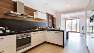 Modern kitchen with wooden cabinets, black countertops, and natural light