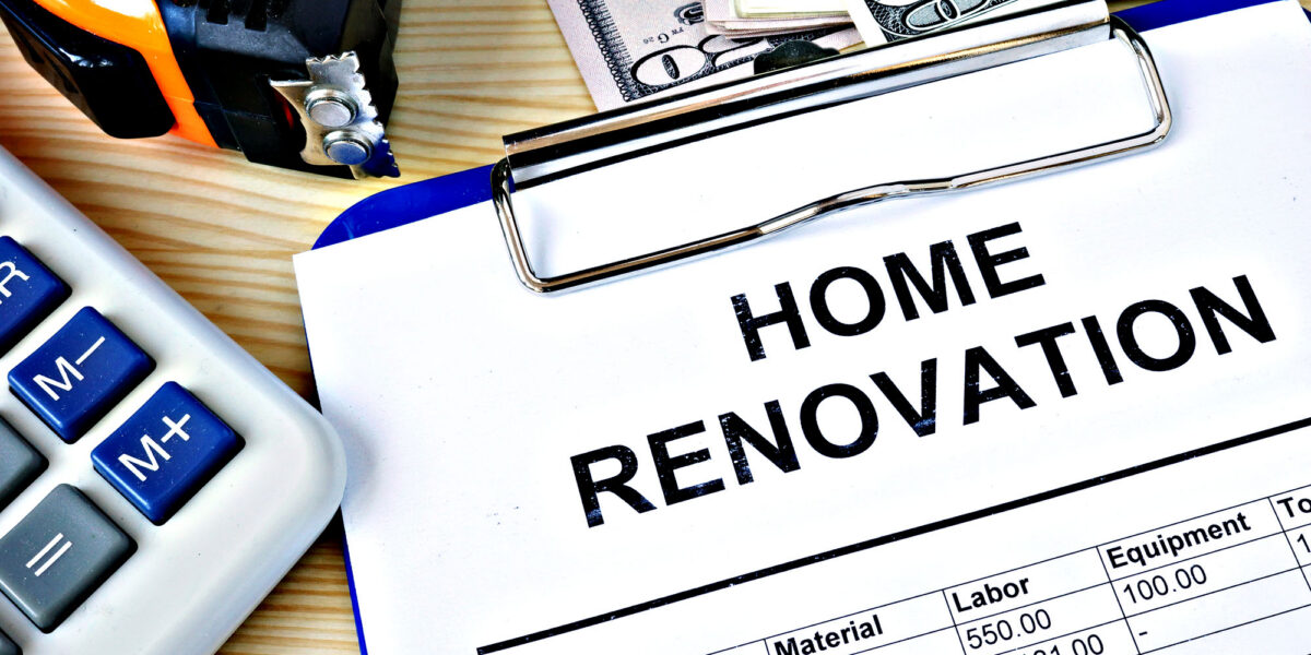 Clipboard with home renovation budget, calculator, and cash