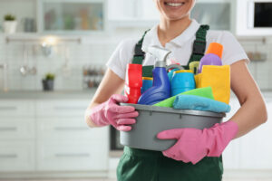 Person holding cleaning supplies in a modern kitchen