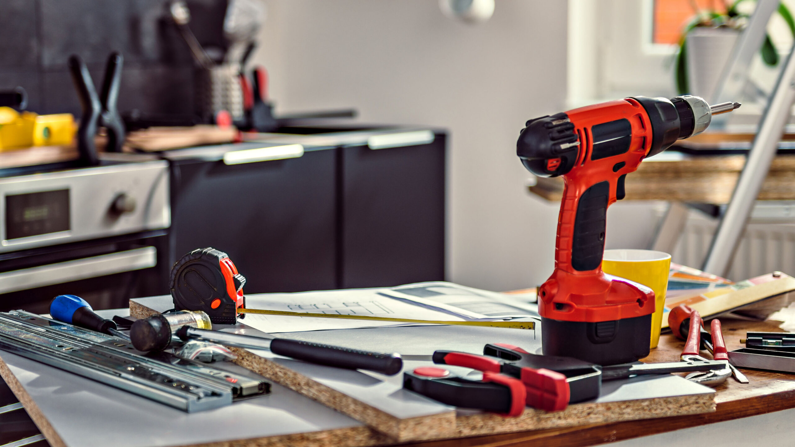 Red cordless drill and tools on kitchen renovation site