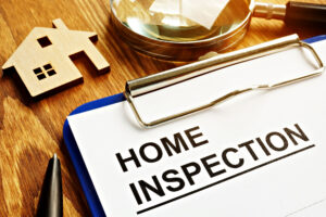 Home inspection checklist with house model on wooden desk
