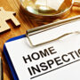 Home inspection checklist with house model on wooden desk