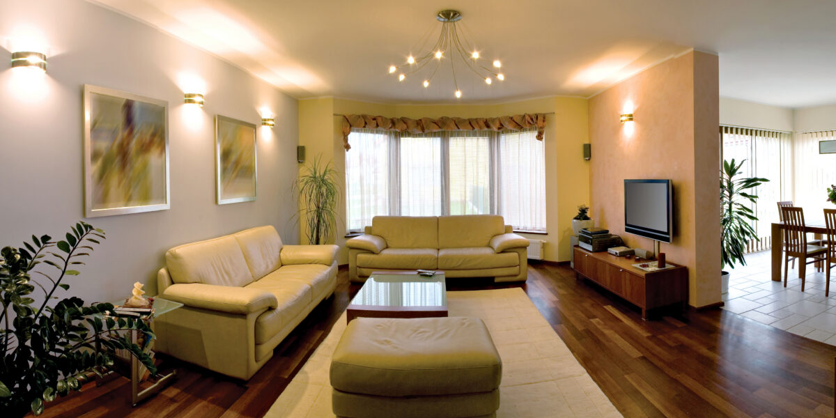Modern living room with beige sofas, wooden floor, and large window