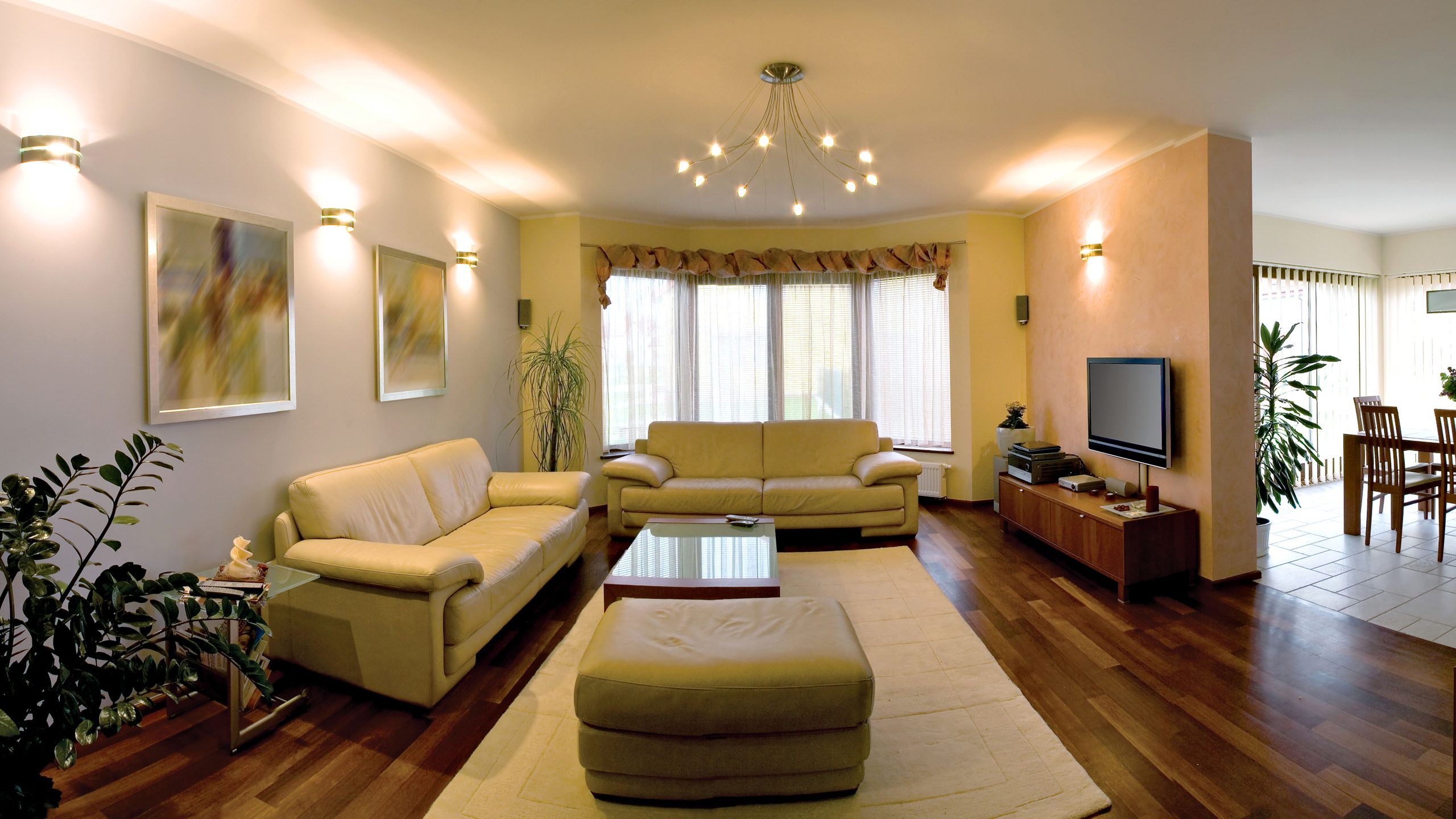 Contemporary living room with beige sofas, hardwood floor, and natural light