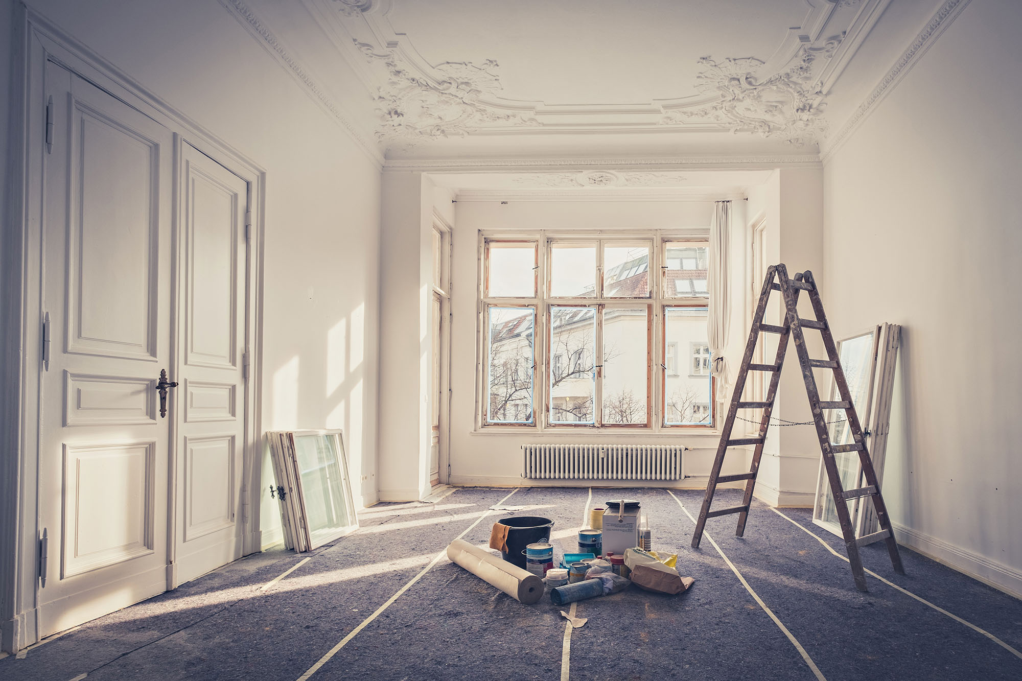 Elegant interior room under renovation with ladder and painting supplies