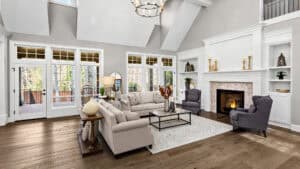 Beautiful living room in new traditional style luxury home. Features vaulted ceilings, fireplace with roaring fire, and elegant furnishings.