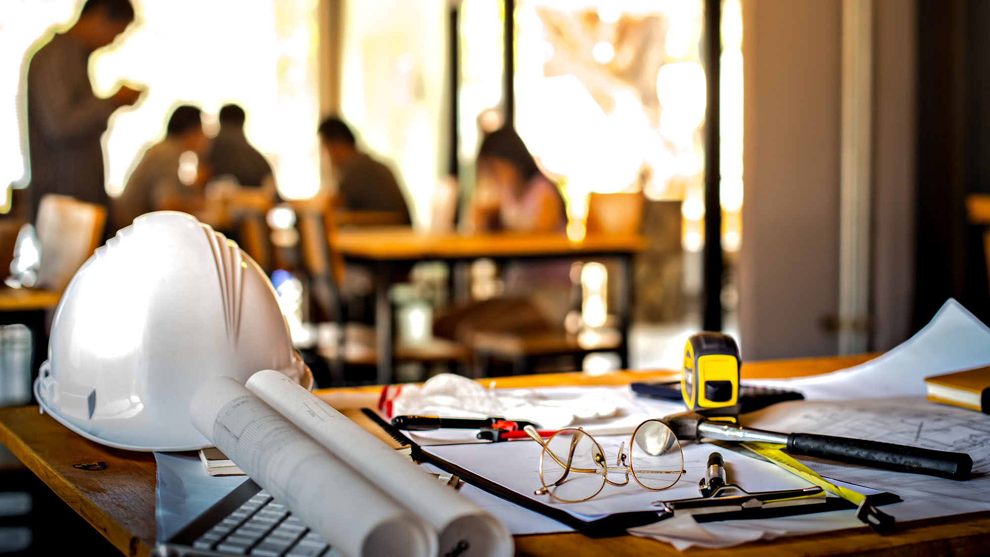 Construction site meeting with blueprints and safety gear