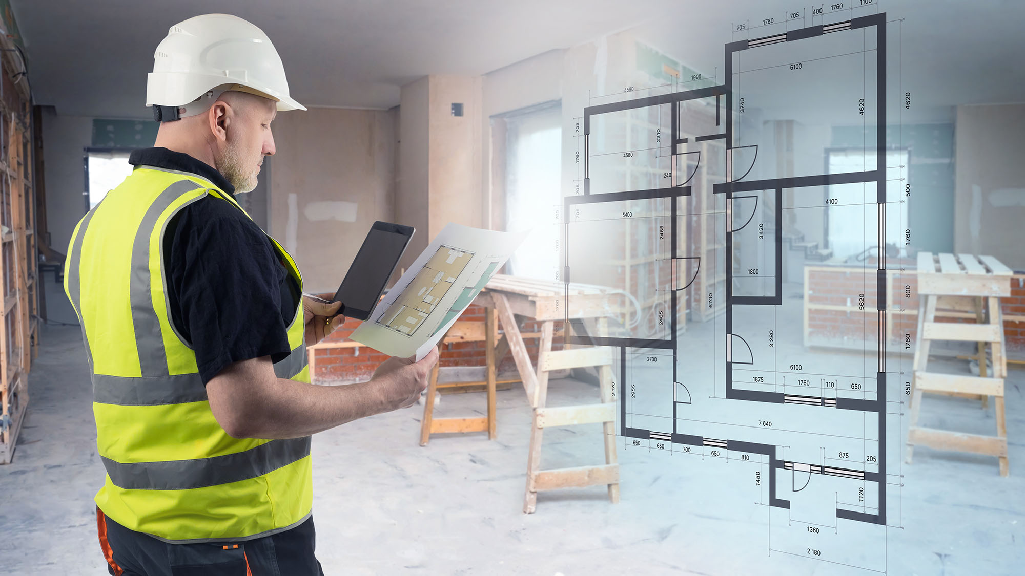 Construction worker reviewing digital architectural plans on site