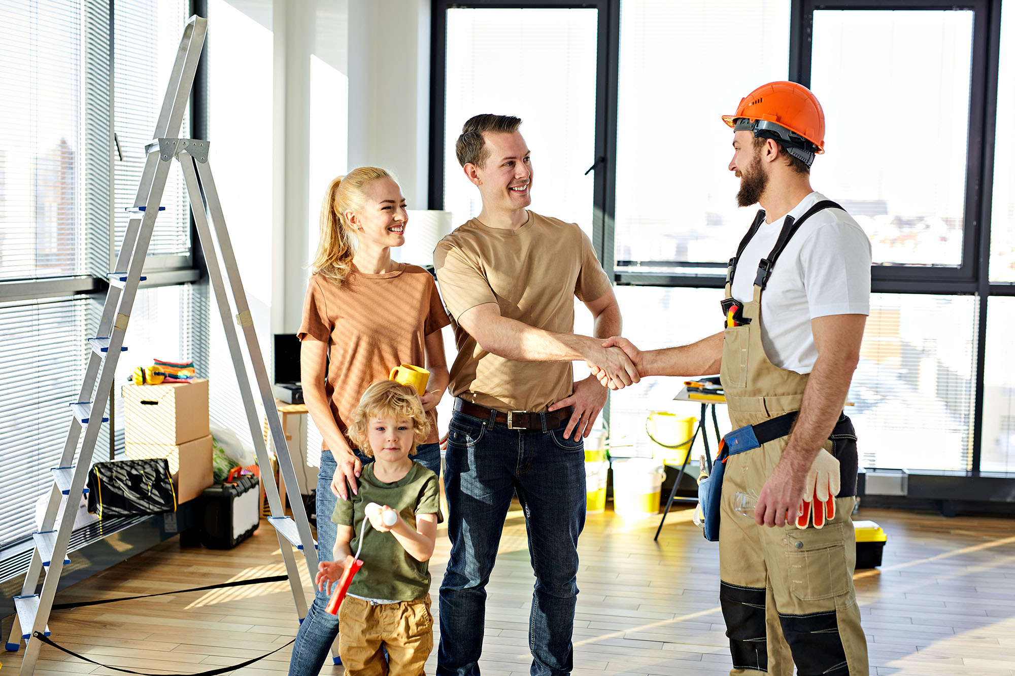 Family shaking hands with contractor in newly renovated home