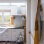 White kitchen undergoing renovations with plastic covering counter.