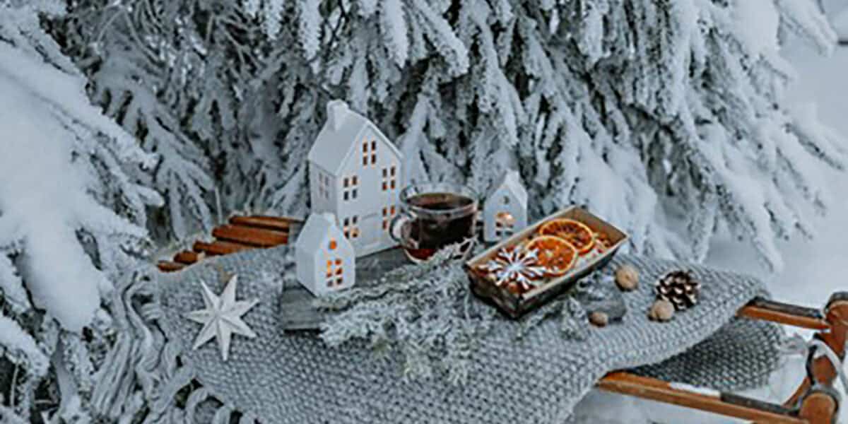 Toy houses underneath Christmas tree with snow