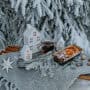 Toy houses underneath Christmas tree with snow