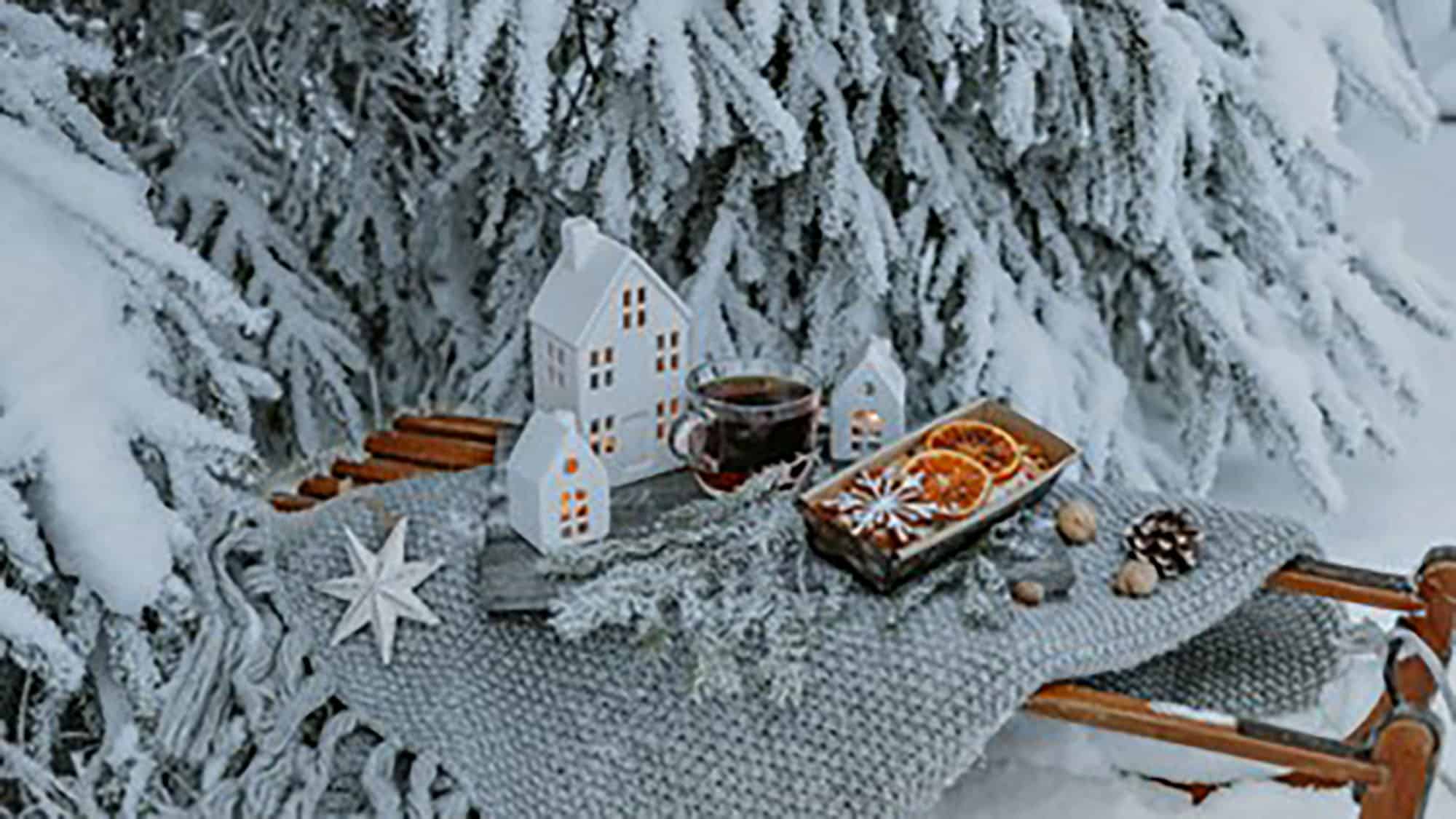 Toy houses underneath Christmas tree with snow