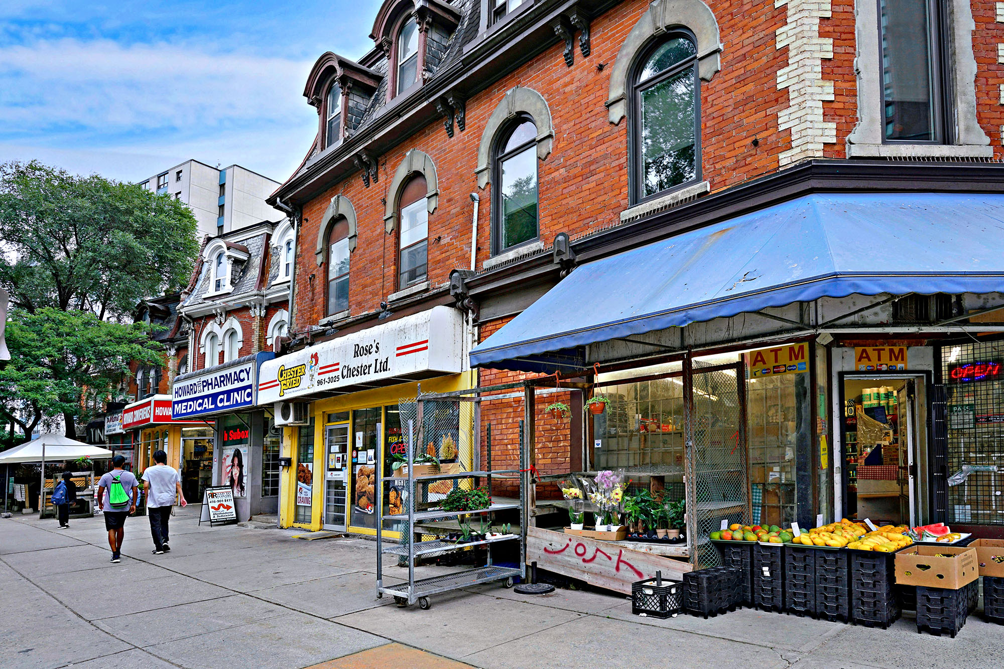 Busy Toronto street with shops and people walking during daytime
