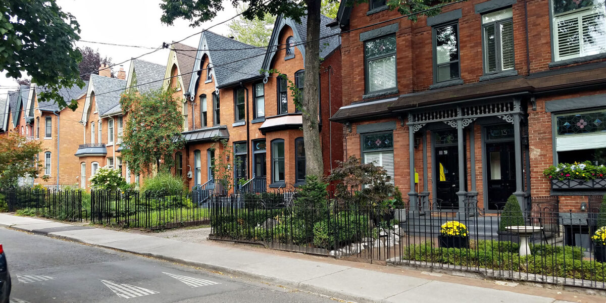 Row of historic brick houses on a tree-lined street in Toronto