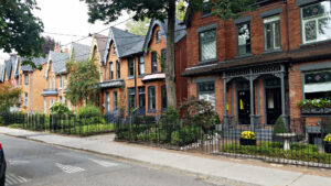 Row of historic brick houses on a tree-lined street in Toronto