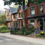 Row of historic brick houses on a tree-lined street in Toronto