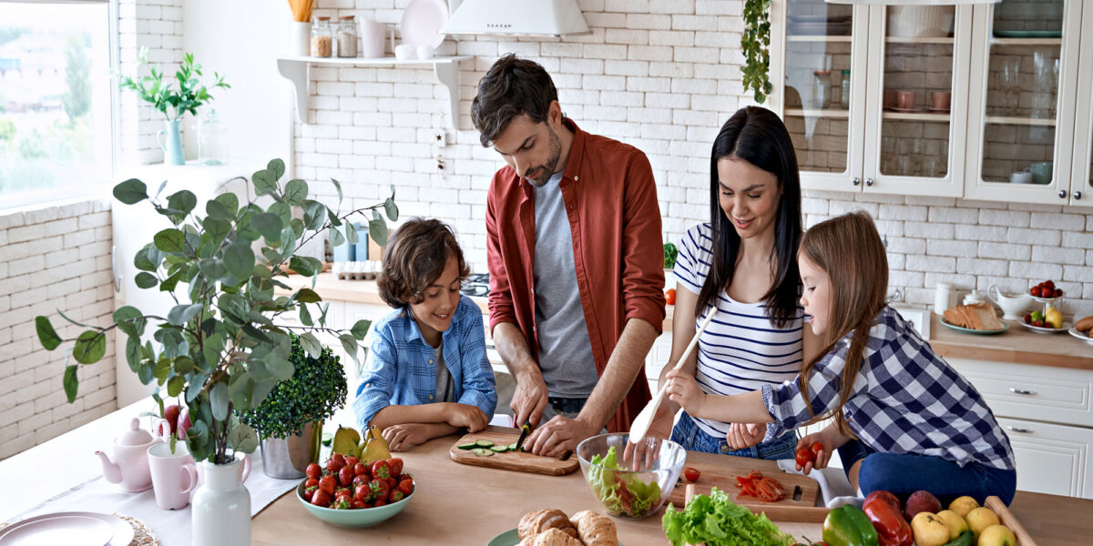 Family cooking together in a bright kitchen with fresh ingredients