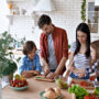Family cooking together in a bright kitchen with fresh ingredients