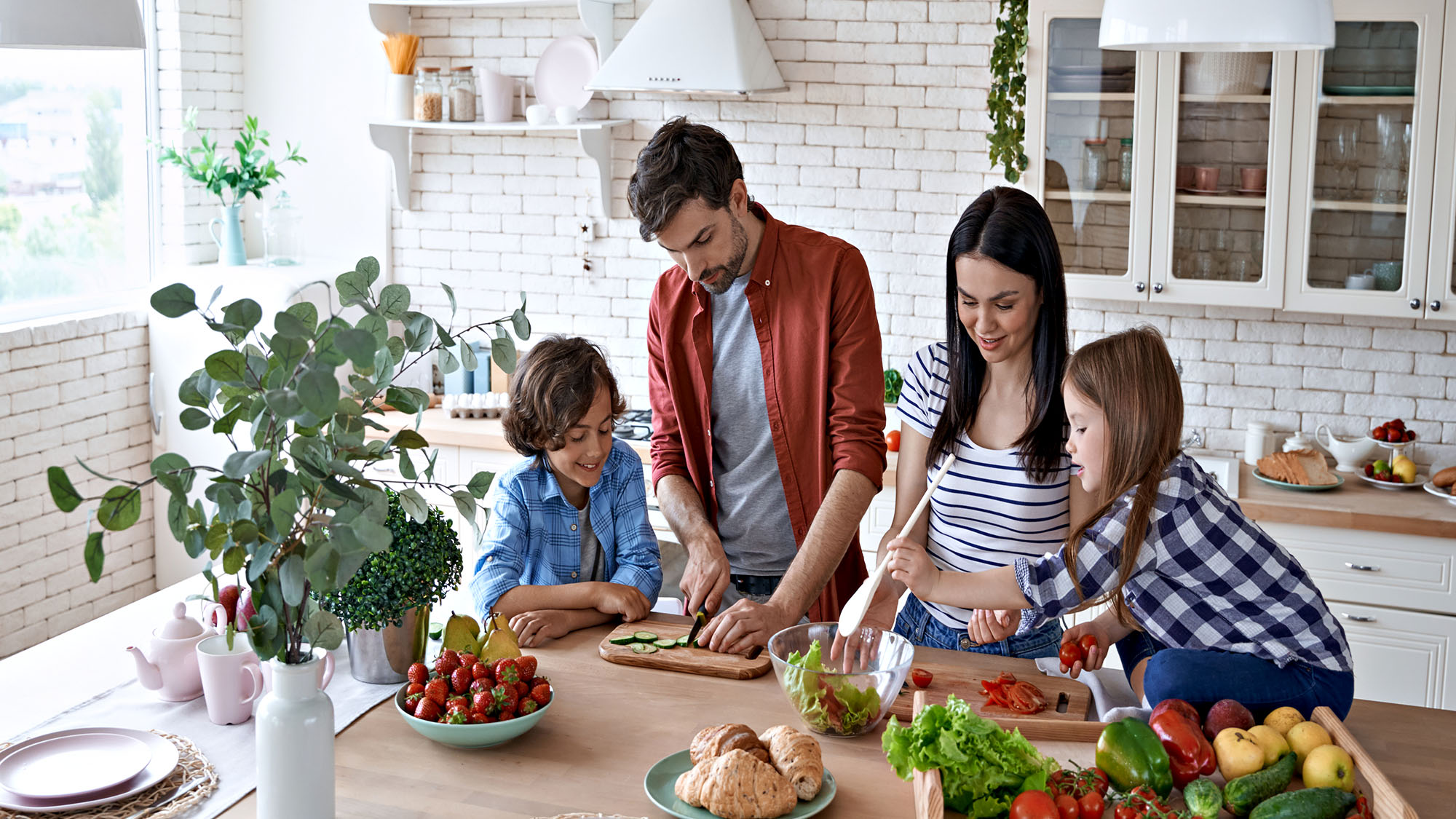 Family cooking together in a bright kitchen with fresh ingredients