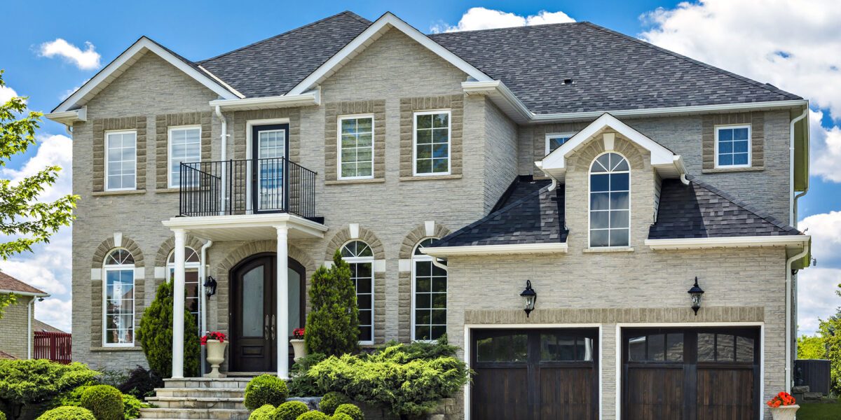 Modern brick and stone home with upper balcony