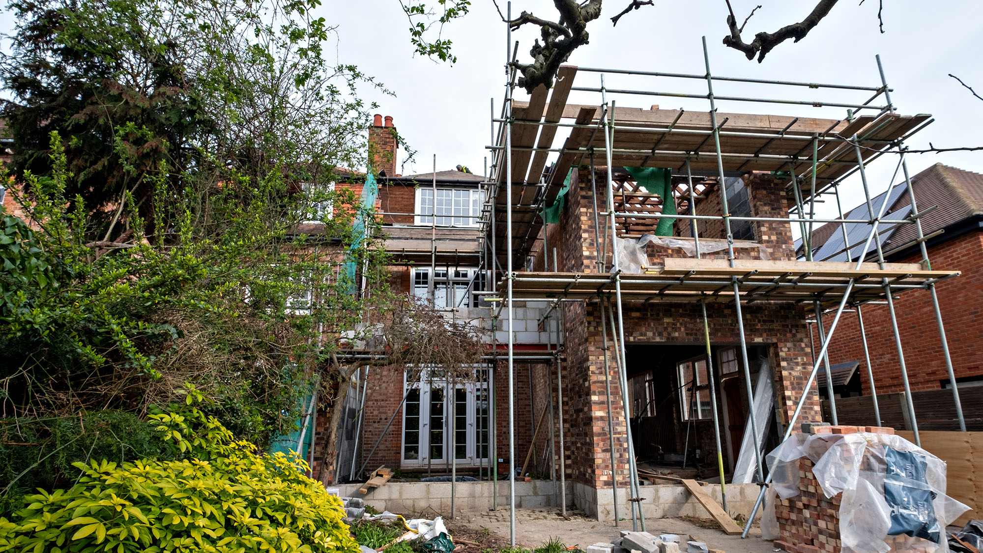 Home renovation project with scaffolding on a brick house