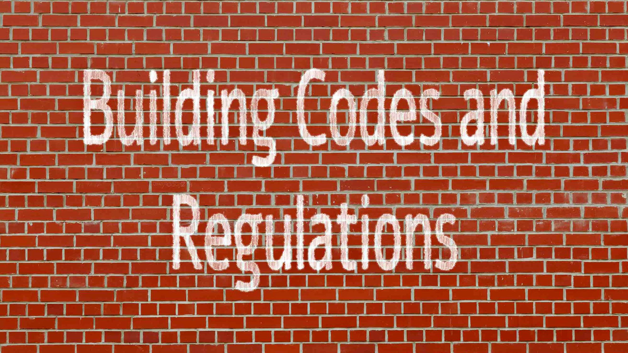 Brick wall with 'Building Codes and Regulations' graffiti