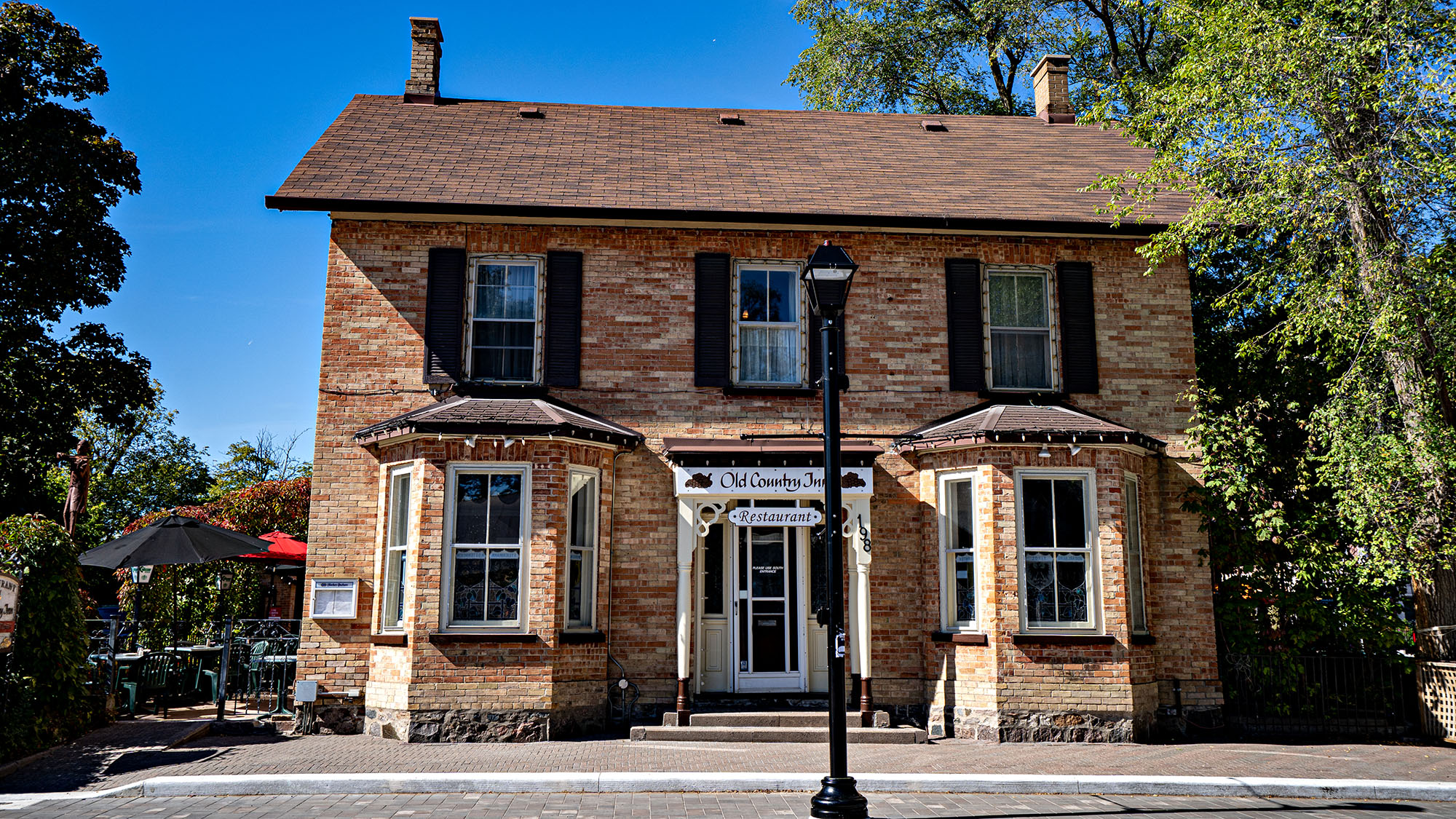 Historic brick building with restaurant patio on sunny day