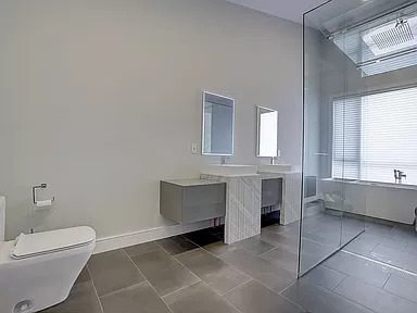 Beautifully appointed bathroom renovation with glass shower, floating shelves, great lighting.