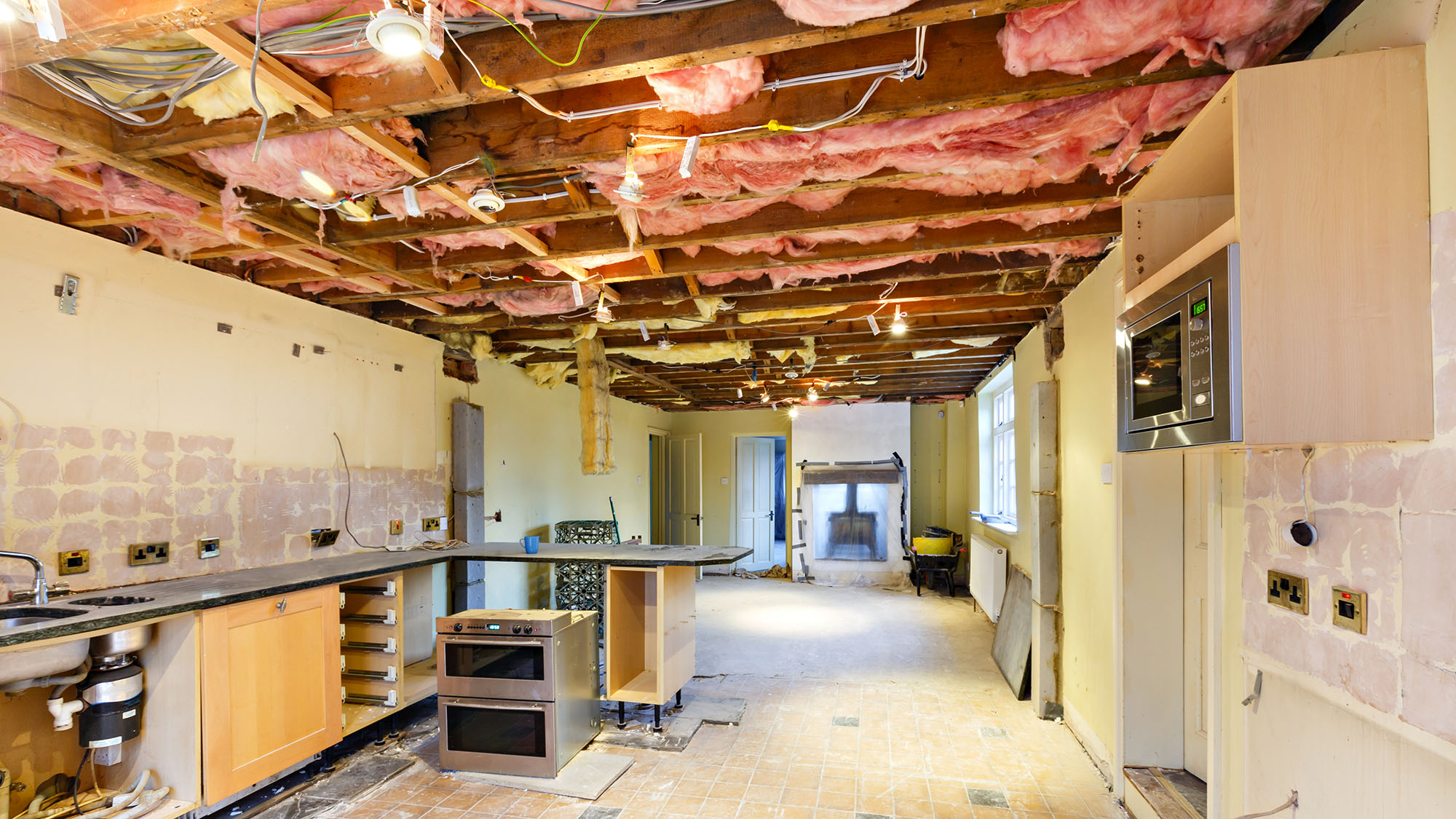 Undergoing kitchen renovation with exposed wiring and insulation