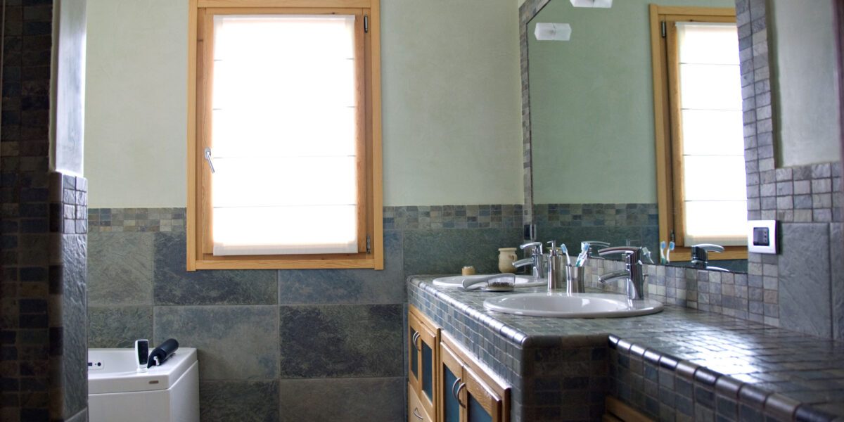 Outdated bathroom with old styee counter and cabinets.